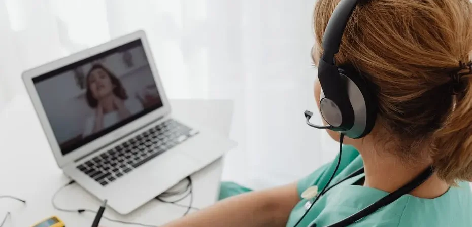 Professionnel de la santé consultant un patient en ligne via un ordinateur portable pour des services de téléconsultation médicale.