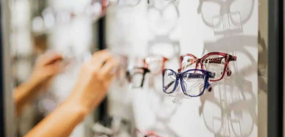 Une variété de lunettes exposées dans un magasin d'optique moderne, présentant différents styles et couleurs.
